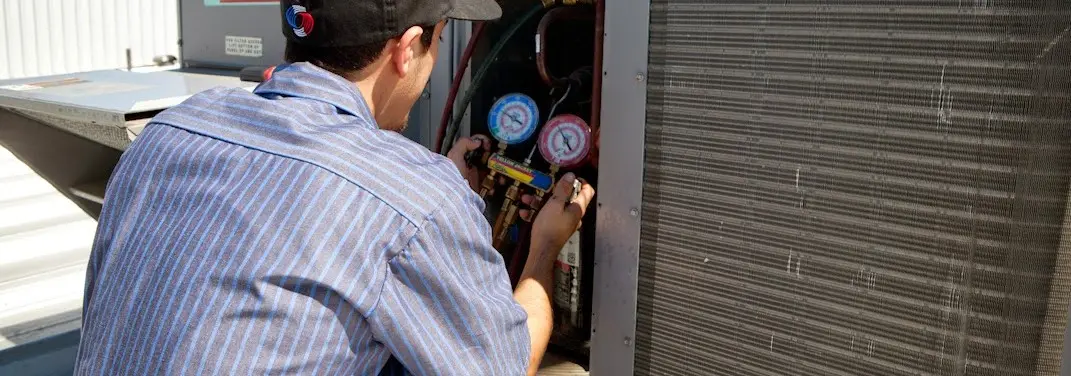 HVAC technician servicing a condenser unit in Upper Freehold
